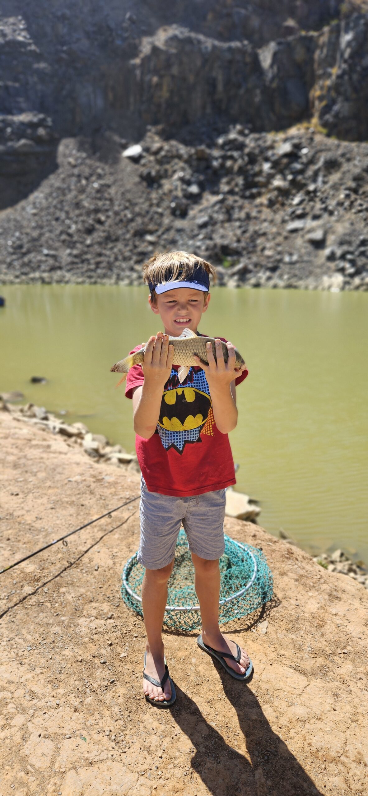 Young boy named Geordi proudly holding a freshly caught fish at Hillcrest Quarry during a JBK Outdoors Catch Club session on 7 December 2025.