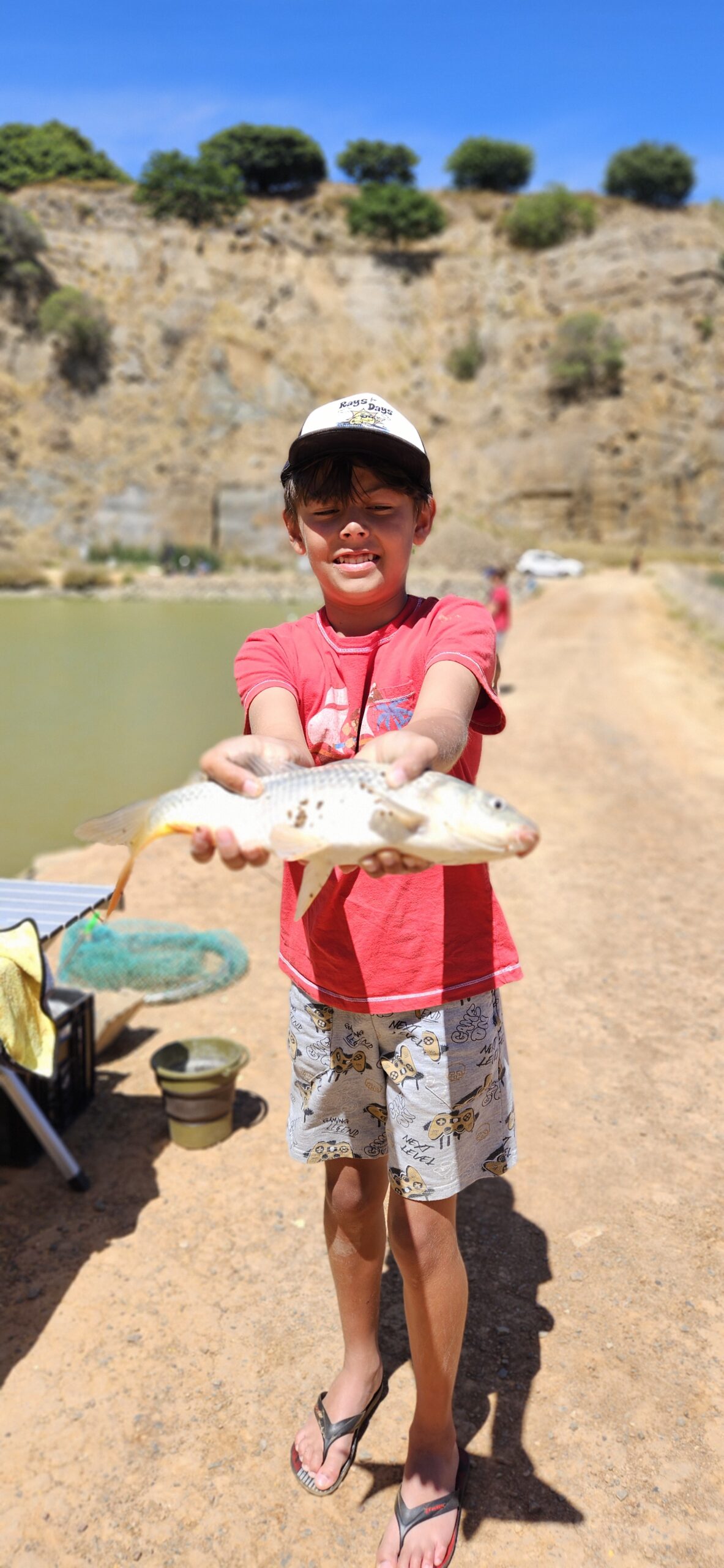 Smiling boy named Rylee proudly holding a fish he caught during a Catch Club session at Hillcrest Quarry on 7 December 2025.